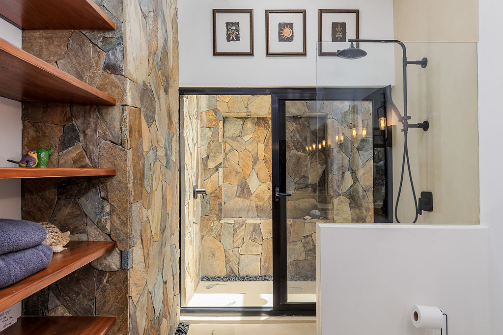 Indoor outdoor shower suite surrounded by garden greenery